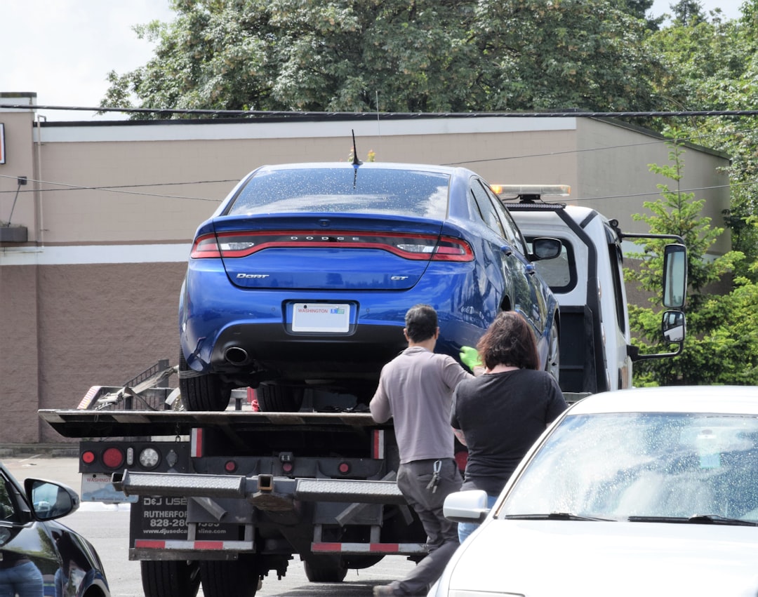 services-03 a-blue-car-being-loaded-onto-a-flatbed-truck-uanilb8zkta